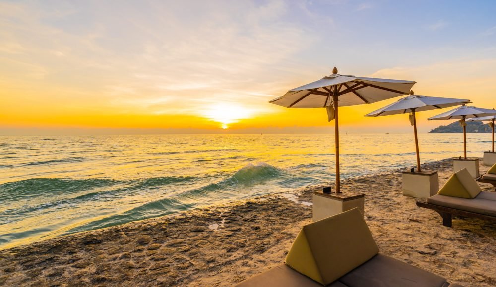 Umbrella and chair with pillow around beautiful landscape of bea